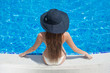 © popovich22 - Young beautiful woman sitting on the ledge of the pool in black