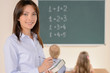 © BlueSkyImages - Confident teacher. Cheerful young teacher smiling at camera whil
