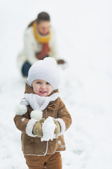 Wall Mural - Happy baby playing with mother in winter park
