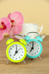 Colorful alarm clock on table on beige background