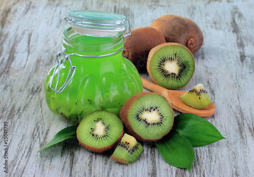 Fototapeta na wymiar Jar of jam kiwi on wooden table close-up