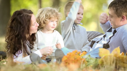 Poster - Happy family playing outdoors in autumn park. Dolly shot