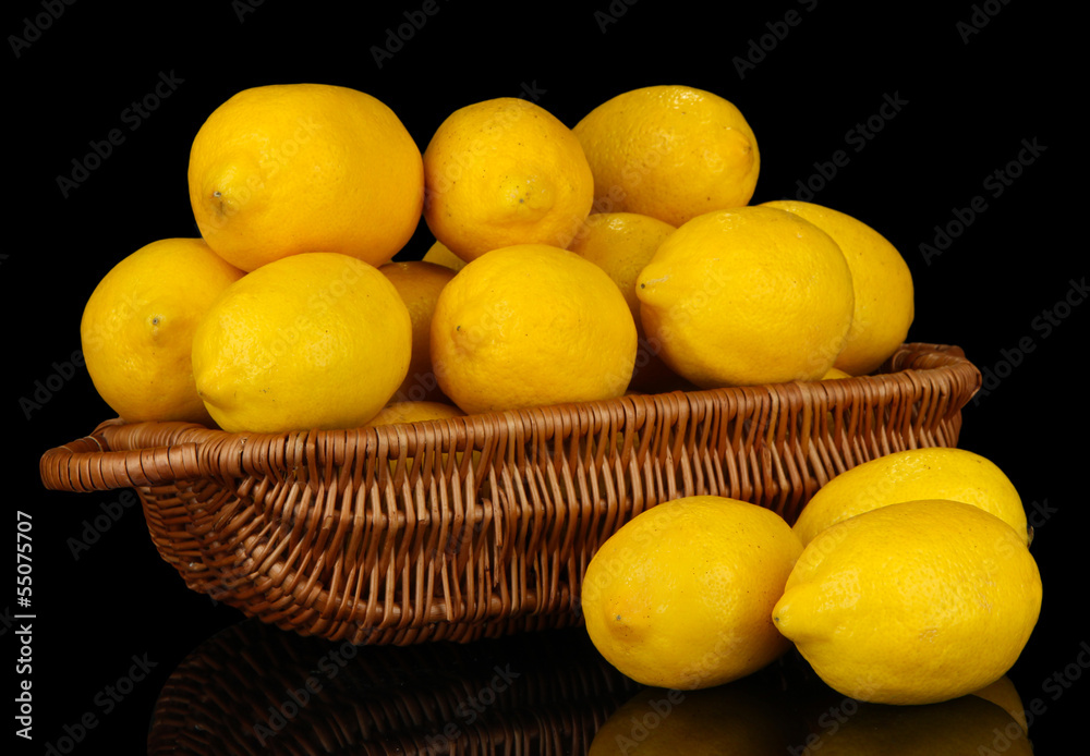 Ripe lemons in wicker basket isolated on black