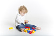 © mikhaluk - Young boy is playing with colorful blockss on the floor