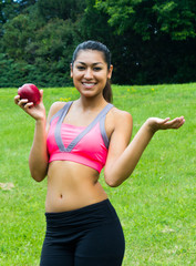 Fit young woman with an apple in the park