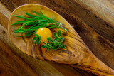 Fototapeta Kuchnia - Drewniana łyżka z ziołami i żółtym pomidorem