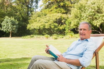 Wall Mural - Happy mature man holding book