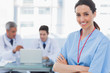 © WavebreakmediaMicro - Doctors using laptop and a smiling nurse crossed her arms