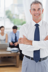 Executive standing on foreground with colleagues on background