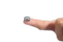 Woman Hand Holding A Button Battery With The Forefinger