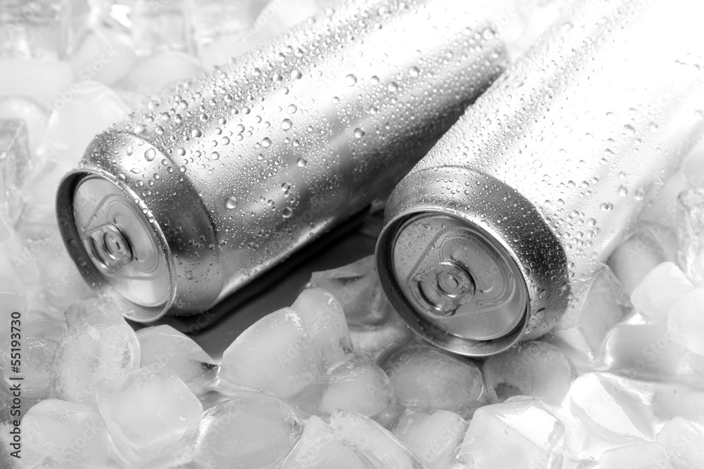 Metal cans of beer with ice cubes, close up