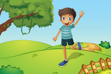 Wall Mural - A happy boy waving while running in the hill