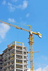 Crane and building construction site against blue sky