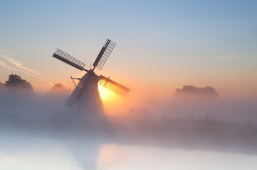 Fototapete - Dutch windmill in dense fog
