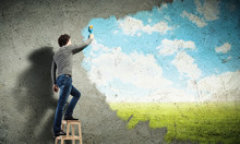 Young Man Drawing A Cloudy Blue Sky