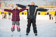 © Pavel Losevsky - Boy and girl skating on rink and making hands to side