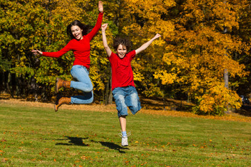 Wall Mural - Girl and boy running, jumping in park