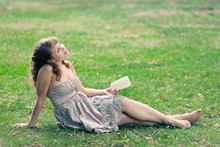 Beautiful Young Woman Reading A Book Outdoors