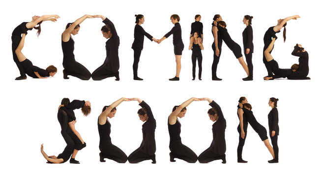 Group of black dressed people standing forming COMING SOON word