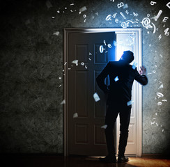 Wall Mural - Young businessman opening door