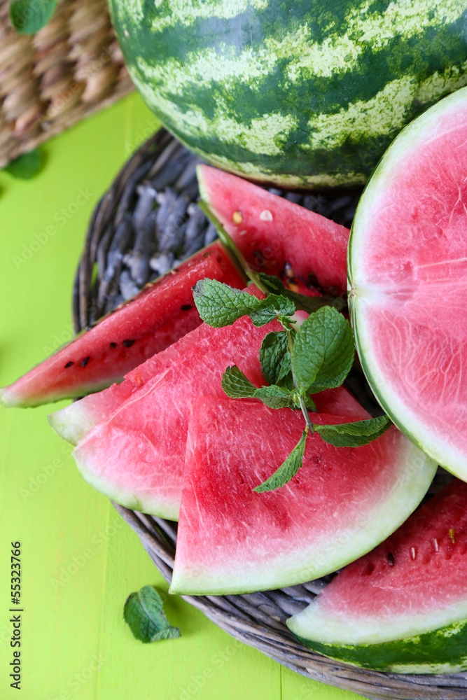 Ripe watermelons on wicker tray  on wooden table