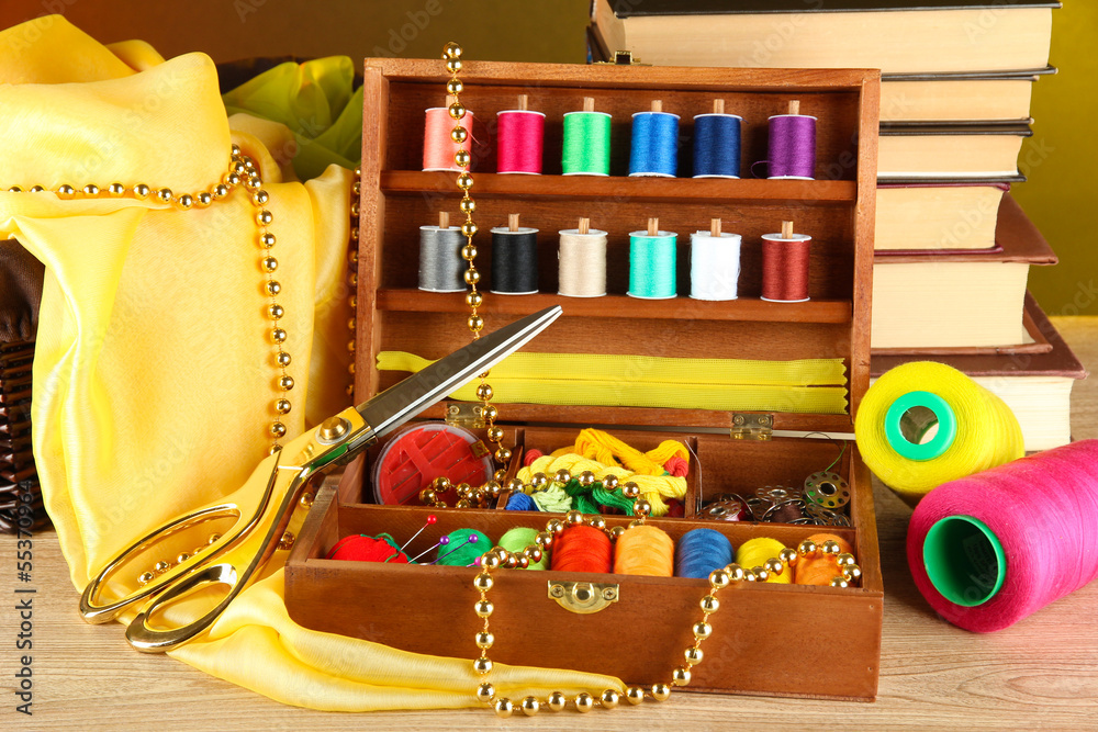 Sewing kit in wooden box with books and cloth table