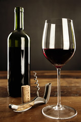 Wall Mural - Glass of red wine, corkscrew and bottle on a table