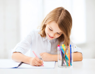 Wall Mural - little student girl drawing at school