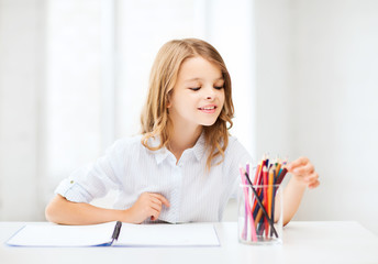 Canvas Print - girl drawing with pencils at school