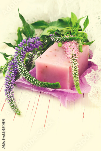 Fototapeta na wymiar Handmade lavender soap with flowers on white wooden table