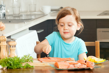 Baby housewife cooking salmon