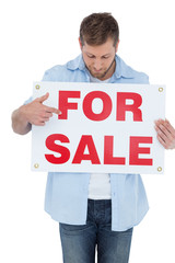 Poster - Trendy model holding a for sale sign and looking at it