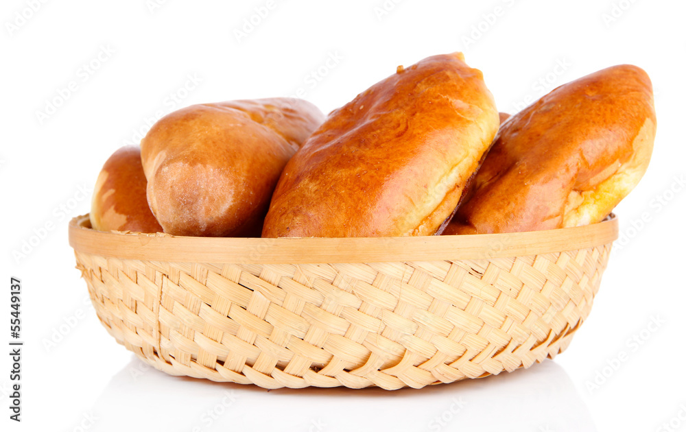 Fresh baked pasties in wicker basket, isolated on white