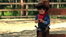 Little Cowboy Standing Near A Wooden Fence Paddocks
