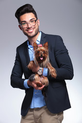 Poster - casual young man holds puppy in both hands