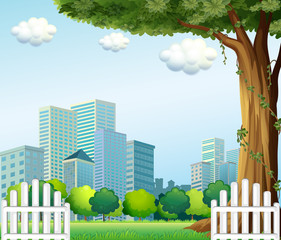 Poster - A giant tree near the wooden fence across the tall buildings