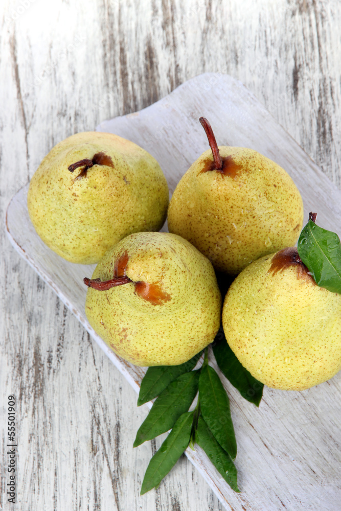 Pears on board on wooden background