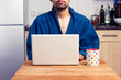 © LoloStock - Man in robe working from home