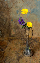 Purple And Yellow Wildflowers In An Antique Silver Vase On A Sla