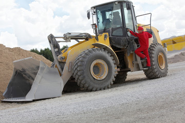 Driver opening cab door to  bulldozer  on construction site