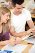 © luckybusiness - Student couple looking at tablet pc