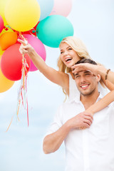 Poster - couple with colorful balloons at seaside