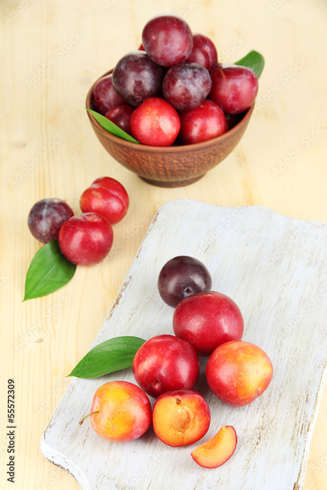 Ripe plums on wooden table close-up