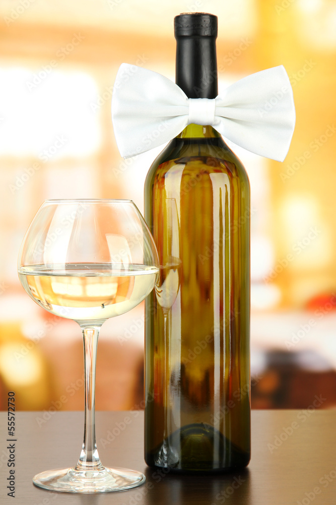 White bow tie on wine bottle on bright background