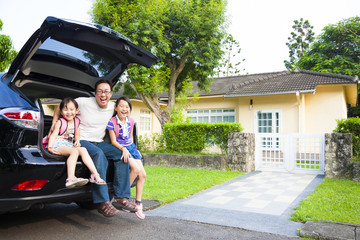 Wall Mural - happy family sitting in the car and their house behind