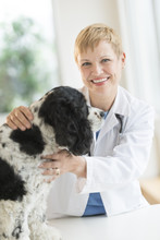 Happy Female Veterinarian Examining Dog