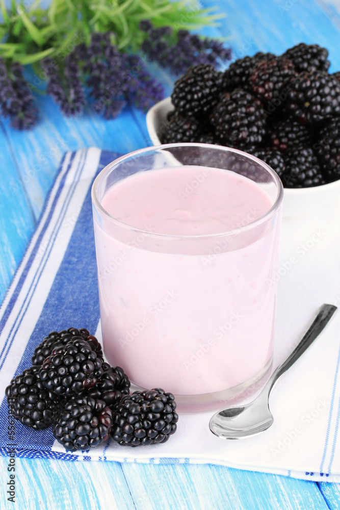 Sweet blackberries with yogurt on table close-up