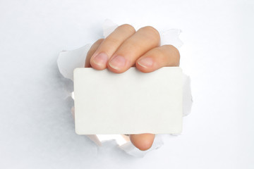 Wall Mural - Hand holds white card through white torn paper .
