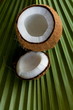 Opened coconut with milk inside on palm leaf