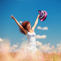 Cute woman running in the field with flowers